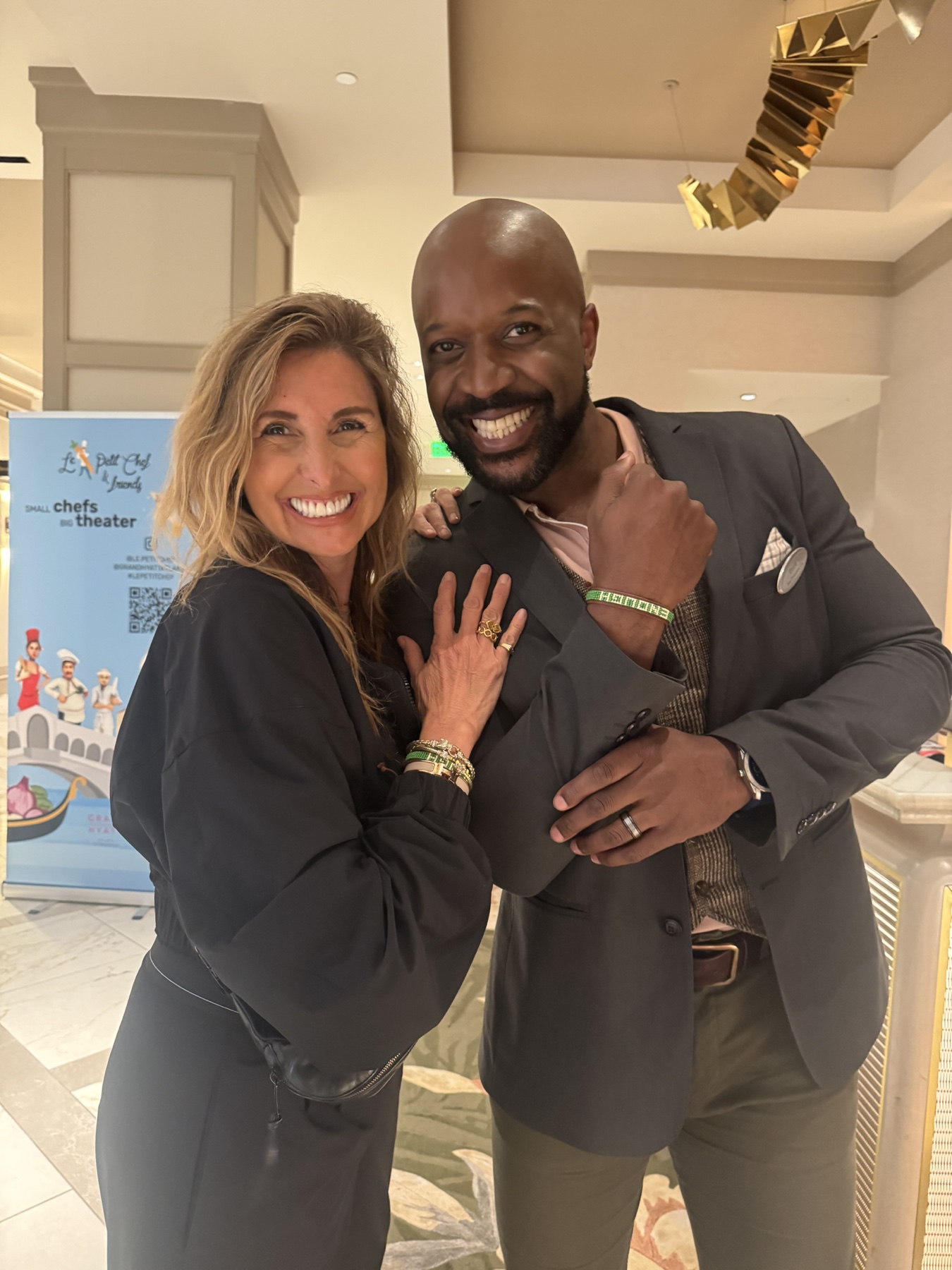 Jill with a World of Hyatt manager, both wearing ENOUGH bracelets